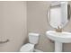 Well-lit half-bath features a pedestal sink, round mirror, and modern fixtures at 535 Summit River Dr, Apopka, FL 32712