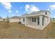 View of backyard showing home's exterior with covered patio and surrounding greenery at 2111 Riely Ave, Eagle Lake, FL 33839