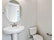 Bathroom featuring a white pedestal sink, toilet, oval mirror, and neutral wall paint at 2111 Riely Ave, Eagle Lake, FL 33839