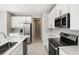 Modern kitchen with stainless steel appliances, a center island, white cabinets, and stylish fixtures at 2111 Riely Ave, Eagle Lake, FL 33839