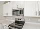 Close up of the modern oven, microwave, and quartz countertop with a white kitchen cabinet background at 2111 Riely Ave, Eagle Lake, FL 33839