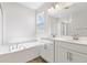 Bright bathroom featuring double vanity sinks, a soaking tub, and a glass-enclosed shower at 2115 Riley Ave, Eagle Lake, FL 33839