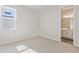 Carpeted bedroom with a window and an ensuite bathroom featuring tile floors and a vanity at 2115 Riley Ave, Eagle Lake, FL 33839