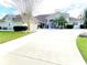Expansive front exterior showcasing well-manicured lawn, circular drive, and mature landscaping at 62 Coquina Ridge Way, Ormond Beach, FL 32174