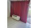 Living room with red curtains and an air conditioning unit at 7900 S Orange Blossom Trl # 1120, Orlando, FL 32809