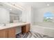 Bright bathroom features a double vanity, soaking tub, and stylish, eye-catching modern floor tiles at 1746 Pompano Dr, Poinciana, FL 34759