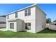 Two-story house exterior with light paint and a neat lawn at 1746 Pompano Dr, Poinciana, FL 34759