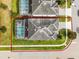 An overhead aerial view showcasing the property's layout, surrounding greenery, and fenced backyard at 9099 Hazard St, Davenport, FL 33896