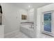 The bathroom features a garden tub with marble tiling, a large window and an exit door to the backyard at 9099 Hazard St, Davenport, FL 33896