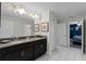Bathroom featuring double sinks with granite countertops, sleek cabinetry, and a view into the adjacent themed bedroom at 9099 Hazard St, Davenport, FL 33896