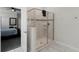 Bright, tiled bathroom features a glass shower and adjoins a carpeted bedroom at 9099 Hazard St, Davenport, FL 33896