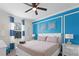 Bright bedroom featuring stylish blue accent wall and a comfortable queen-size bed, creating a cozy and inviting atmosphere at 9099 Hazard St, Davenport, FL 33896