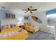 Bright bedroom decorated with coastal-themed décor, including surfboards, art, and colorful bedding at 9099 Hazard St, Davenport, FL 33896