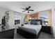 Bedroom with a dark wood dresser, king bed, ceiling fan and bedside tables at 9099 Hazard St, Davenport, FL 33896