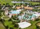 A bird's eye view showcasing a luxurious community pool area, clubhouse, and beach volleyball court surrounded by lush landscaping at 9099 Hazard St, Davenport, FL 33896