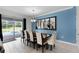 Stylish dining area with a modern chandelier, ample seating, and sliding glass doors leading to the outdoor pool area at 9099 Hazard St, Davenport, FL 33896