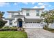 Charming white two-story home featuring an arched entryway, tidy landscaping, and a paved driveway at 9099 Hazard St, Davenport, FL 33896
