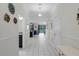 Bright hallway featuring elegant white tile floors, crown molding, and an open view into the living and dining areas at 9099 Hazard St, Davenport, FL 33896