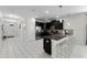 Stylish kitchen with a large island, sleek black cabinets, stainless steel appliances, and white tile flooring at 9099 Hazard St, Davenport, FL 33896