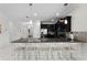 Modern kitchen with a large island with barstool seating, black cabinetry, and stainless steel appliances at 9099 Hazard St, Davenport, FL 33896