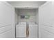 Convenient laundry closet equipped with a washer, dryer, and shelving for storage at 9099 Hazard St, Davenport, FL 33896