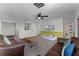 Living room with comfortable seating, television, ceiling fan, and half wall at 9099 Hazard St, Davenport, FL 33896