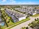 An aerial view of a vibrant neighborhood featuring meticulously landscaped homes with screened-in pools and mature trees at 9099 Hazard St, Davenport, FL 33896