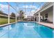 Beautiful in-ground pool and screened-in patio surrounded by lush landscaping for outdoor enjoyment at 9099 Hazard St, Davenport, FL 33896