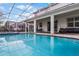 Backyard pool with a screened in patio for outdoor dining, and covered patio space for outdoor living at 9099 Hazard St, Davenport, FL 33896