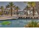 Community pool surrounded by palm trees, lounge chairs, and pool toys at 9099 Hazard St, Davenport, FL 33896
