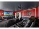 Home theater with red walls, black ceiling, large projector screen and comfortable seating at 9099 Hazard St, Davenport, FL 33896