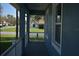 View from the covered front porch of a charming blue house featuring white railings and a glimpse of the neighborhood at 106 Sparrow Ct, Kissimmee, FL 34759