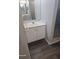 Bathroom featuring a clean white vanity, matching mirror and wood-look floors at 1325 Dunbarton Ct, Kissimmee, FL 34758