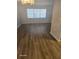 Bright living room featuring wood-look flooring, fresh paint, and a sunlit window at 1325 Dunbarton Ct, Kissimmee, FL 34758