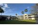 A charming building featuring a grassy courtyard and palm trees against a clear blue sky at 5245 W Irlo Bronson Memorial Hwy # 244, Kissimmee, FL 34746