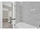 Bright bathroom featuring marble tiled shower and gray wood floors at 544 Orange Dr # 10, Altamonte Springs, FL 32701
