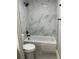 Updated bathroom featuring white marble shower walls and gray wood look flooring at 544 Orange Dr # 10, Altamonte Springs, FL 32701