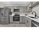 Modern kitchen with stainless steel appliances and gray cabinetry, complemented by light countertops at 544 Orange Dr # 10, Altamonte Springs, FL 32701
