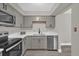 Updated kitchen showcasing stainless steel appliances, gray cabinets, and sleek countertops at 544 Orange Dr # 10, Altamonte Springs, FL 32701