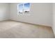 An empty bedroom with plush carpet, a large window offering ample natural light, and neutral tones at 2107 Riley Ave, Eagle Lake, FL 33839