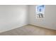 Bright, carpeted bedroom with natural light streaming through a window overlooking a house at 2107 Riley Ave, Eagle Lake, FL 33839