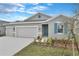 Beautiful single Gathering home with a two-car garage, fresh landscaping, and grey exterior paint at 2107 Riley Ave, Eagle Lake, FL 33839
