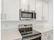 The kitchen features stainless steel appliances, sleek countertops, and white cabinets for a modern look at 2107 Riley Ave, Eagle Lake, FL 33839