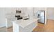 Spacious kitchen featuring an island with modern countertops, stainless steel appliances, and wooden flooring at 2107 Riley Ave, Eagle Lake, FL 33839