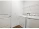 Bright laundry room with modern washer and dryer, tile floor, and wire shelving at 2107 Riley Ave, Eagle Lake, FL 33839