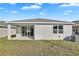 View of the home's exterior with a sliding glass door, window, and a grassy backyard at 814 Ballantyne Dr, Lake Wales, FL 33898