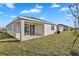The backyard features a covered patio and view of well-maintained lawn at 814 Ballantyne Dr, Lake Wales, FL 33898