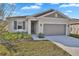 Single-story home with a well-manicured lawn, complemented by a two-car garage at 814 Ballantyne Dr, Lake Wales, FL 33898