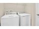 Functional laundry room with white washer and dryer units and overhead shelving for storage at 814 Ballantyne Dr, Lake Wales, FL 33898