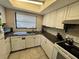 Well-lit kitchen featuring white cabinets, granite countertops, and modern appliances at 1493 Magellan Cir # 504, Orlando, FL 32818